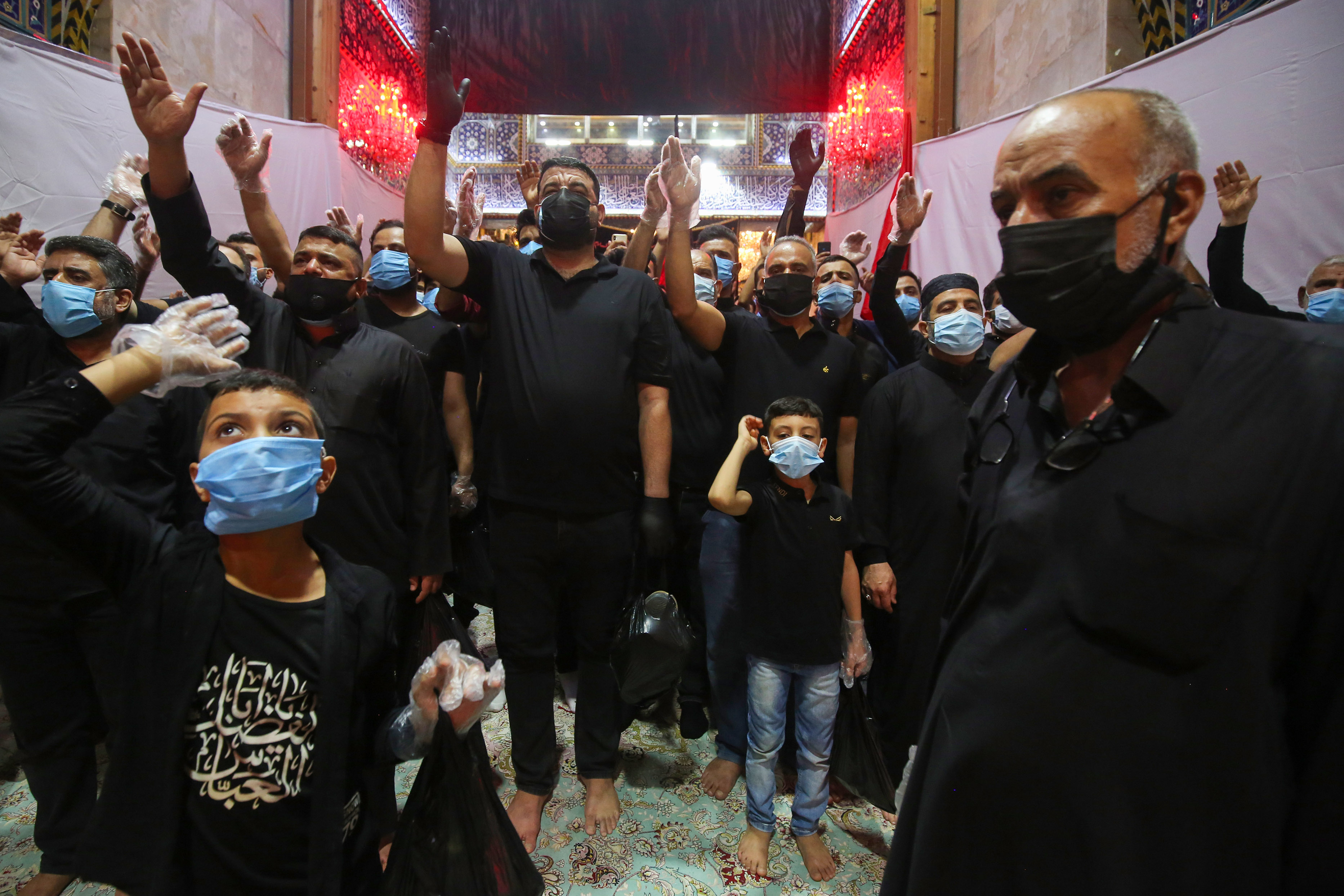 Shia Muslim worshippers, wearing protective face masks, attend a mourning ritual to commemorate martyrdom of Prophet Mohammad's grandson Imam Hussein during the Islamic month of Muharram in his shrine in Iraq's central holy shrine city of Karbala. August 29, 2020. (Photo: Ahmad al-Rubaye/AFP)